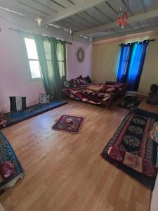 Habitación grande con alfombras en el suelo y ventanas en Renuka homestay and cafe, en Kasol