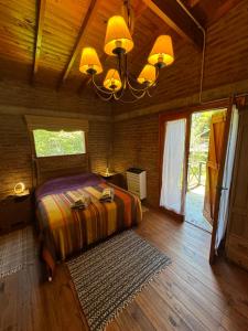 a bedroom with a bed and a chandelier at Cabañas Arehue in Mar del Plata