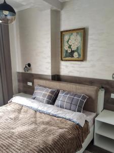 een bed in een slaapkamer met een foto aan de muur bij Apartments in the center in Chişinău