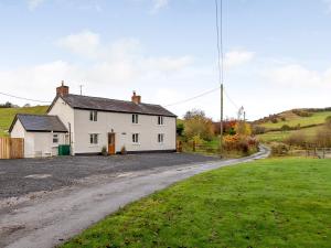 a white house on a dirt road at 3 Bed in Llandrindod Wells 65885 in Llanbadarn-fynydd