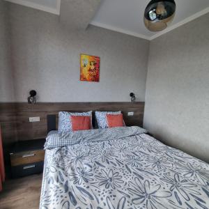 a bedroom with a bed with a blue and white comforter at Apartments in the center in Chişinău