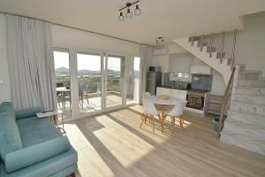 a living room with a blue couch and a table at Eleonas View Suites in Nea Peramos