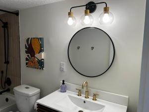 La salle de bains est pourvue d'un lavabo et d'un miroir mural. dans l'établissement Be A Nomad Apartments Blocks to the Beach, à Jacksonville Beach