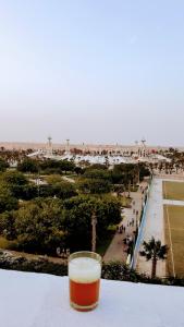 a glass of beer sitting on a table looking at the beach at Résidence London in Laayoune +18 photos