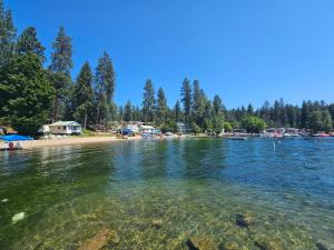 a body of water with a beach and trees at Granite Point Resort in Loon Lake