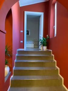 a staircase in a room with red walls at "le Volte" Appartamento nel cuore di Foligno in Foligno