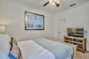 a bedroom with a bed and a flat screen tv at Coral By AvantStay Gorgeous Three Story Home w Two Balconies in Destin