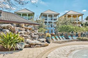 a resort with a rock wall and chairs and a pool at Coral By AvantStay Gorgeous Three Story Home w Two Balconies in Destin