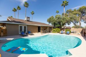 a swimming pool in front of a house with palm trees at West Ridge by AvantStay A Place Of Comfort Perfect Sunsets by the Pool ❤ in Scottsdale