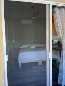 a view of a bed through a sliding glass door at Casa Berita in Yelapa