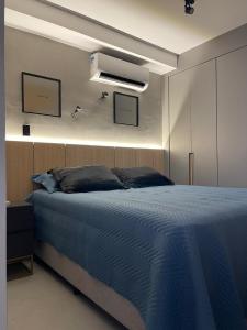 a bedroom with a bed with a blue blanket at hihome - Independência 915 in Juiz de Fora