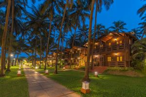 a resort with palm trees in front of a building at La Cabana Beach & Spa, By Ashvem Beach in Mandrem