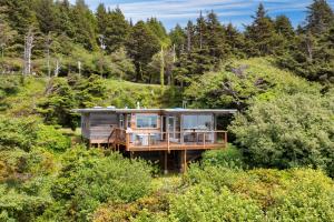 una casa en medio de un bosque en Sunset Cove by AvantStay Beachfront w Balcony, en Arch Cape