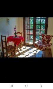 a dining room with a table and two chairs at Ninho dos Passaros Penedo RJ in Penedo
