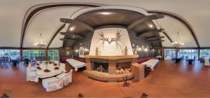 a large room with a fireplace and tables and chairs at Hotel Restaurant Zum Jägerheim in Braunschweig