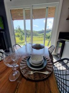 una mesa con un plato de comida y copas de vino en TinyWine House Vale dos Vinhedos en Garibaldi