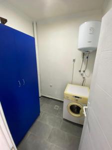 a bathroom with a toilet and a blue door at Apartmani Popov in Vrbas