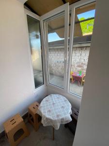 a room with two windows and a table and two stools at Apartmani Popov in Vrbas