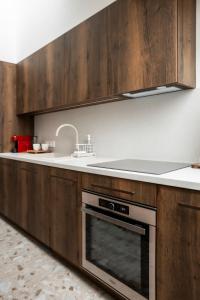 a kitchen with wooden cabinets and a stove top oven at Loft 27 in Kaunas +8 photos