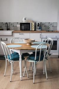 a kitchen with a table and chairs in a kitchen at Maupiti proche Etretat et Fécamp in Vattetot-sur-Mer