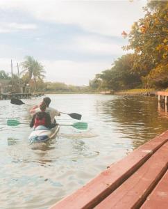 a couple of people in a paddle boat in the water at Nômades Adventure Hostel & Coworking in Florianópolis
