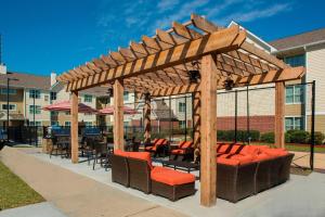 a wooden pergola with chairs and tables on a patio at Residence Inn by Marriott New Orleans Metairie in Metairie