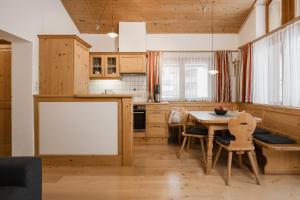 a kitchen with a table and chairs and a whiteboard at Apart Tyrol in Serfaus
