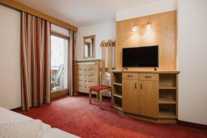 a hotel room with a television and a bedroom at Apart Tyrol in Serfaus