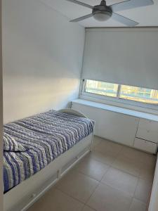 a small bedroom with a bed and a window at Edificio Calypso - Primera línea al Mar in Punta del Este