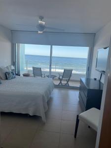 a bedroom with a bed and a view of the ocean at Edificio Calypso - Primera línea al Mar in Punta del Este