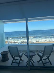 a room with two chairs and a table and a view of the ocean at Edificio Calypso - Primera línea al Mar in Punta del Este