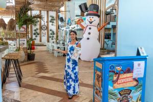 Una mujer parada junto a un muñeco de nieve en una tienda en La Palma Beachfront Hotel Boutique - Self Check In en Cancún