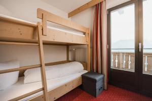 a bedroom with bunk beds with a balcony at Apart Tyrol in Serfaus