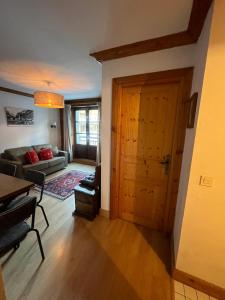 uma sala de estar com um sofá e uma porta de madeira em Adorable 30m2 Coeur de Val 1 chambre 2 lits em Val dʼIsère