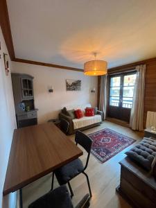 uma sala de estar com uma mesa e um sofá em Adorable 30m2 Coeur de Val 1 chambre 2 lits em Val dʼIsère