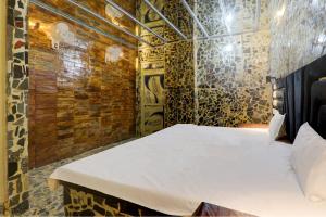 uma cama num quarto com uma parede de tijolos em Super OYO A.S.Castle em Kākori