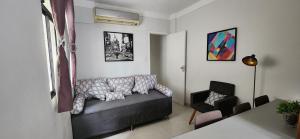a living room with a couch and a chair at Lindo Apartamento compacto na quadra da praia in Santos