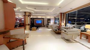 ein großes Wohnzimmer mit Sofas und einem TV in der Unterkunft Al Joon Aparthotel in Riad