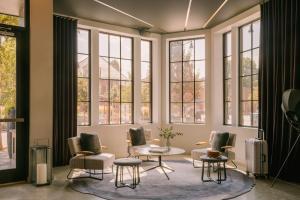 a living room with chairs and a table and windows at Sonder 907 Main in Cambridge