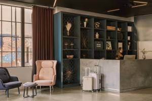 a lobby with two chairs and a woman with a suitcase at Sonder 907 Main in Cambridge