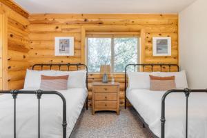 2 camas num quarto com paredes de madeira em Tanglewood by AvantStay 10mins to Bear Mountain Contemporary Hillside Cabin em Big Bear Lake