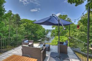 un patio con mesa y sombrilla en Hummingbird Home by AvantStay Boat House Dock, en Statesville