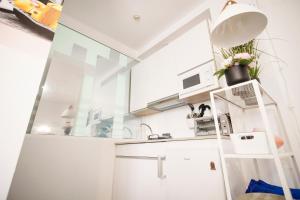 una cocina con armarios blancos y una escalera en Apartamento turístico Travelers, en Baena
