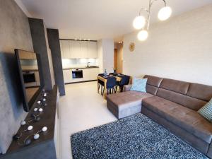 uma sala de estar com um sofá e uma sala de jantar em Apolonia apartamenty I - SPA em Dziwnów