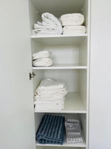 un armario lleno de toallas blancas en los estantes en One bedroom in center with Terrace and Parking, en Luxemburgo