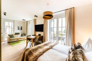 - une chambre avec un lit et un salon dans l'établissement Black Forest Luxury Apartment Waldglück mit Sauna, à Königsfeld im Schwarzwald