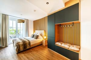 sypialnia z łóżkiem i dużym oknem w obiekcie Black Forest Luxury Apartment Waldglück mit Sauna w mieście Königsfeld im Schwarzwald