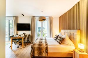 - une chambre avec un lit, une table et un bureau dans l'établissement Black Forest Luxury Apartment Waldglück mit Sauna, à Königsfeld im Schwarzwald