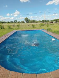 uma piscina de água azul num deque de madeira em Quintas La escondida em Chivilcoy