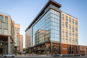 un edificio de cristal alto con coches estacionados frente a él en Le Méridien Salt Lake City Downtown, en Salt Lake City